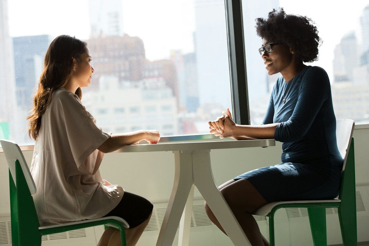 Dos mujeres hablan en una oficina luminosa